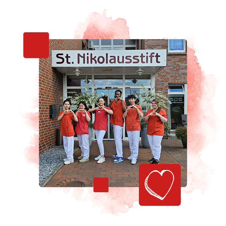 Teamfoto vor dem St. Nikolausstift. Alle zeigen mit den Händen ein Herz.